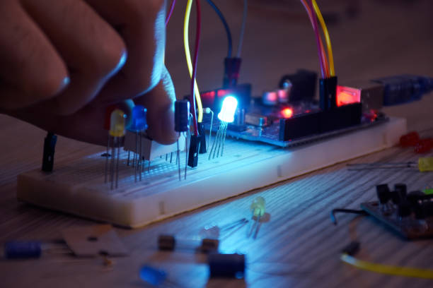 An engineer working on arduino project, breadboard, electronic module